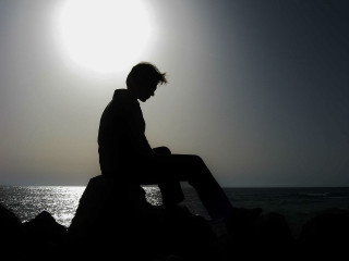 Man sitting rock ocean sunshine - the ocean in the background free wallpaper