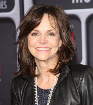 Woman black jacket pearls smiling - a photo free wallpaper