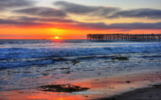 Sunset ocean pier waves crashing - a sunset over the ocean free wallpaper