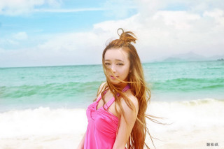 Woman pink dress beach ocean - flowing hair free wallpaper