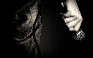 Person holding microphone black background - photo of a person holding free wallpaper