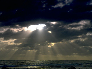Sunbeam clouds ocean beach surfboard - a surfboard in the foreground free wallpaper