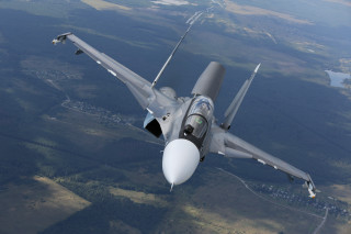 Fighter jet flying over trees - the background and a river free wallpaper