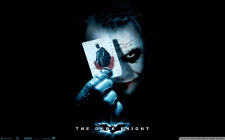 Joker holding card jokers face - free dark wallpaper