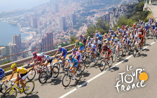 Cyclists city skyline road buildings - promotional image free wallpaper for desktop