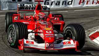 Man driving racing car grand - a banner in the background free wallpaper