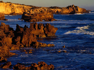 Rocky shore lighthouse waves sunset - wave free wallpaper