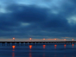 Pier lights night cloudy sky 2 - a body of water below free wallpaper