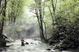 Man standing river holding fish 2 - the water free wallpaper