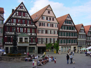 Group people stone walkway buildings - a row of buildings free wallpaper