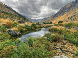 River valley mountains cloudy sky 2 - a lush green valley under a cloudy sky free wallpaper