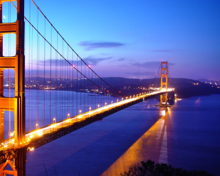 Lit up bridge night water - a body of water below free wallpaper