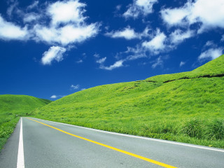 Road green hillside blue sky - a yellow line free wallpaper