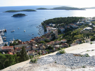 Village hill water island boats - a small island in the distance free wallpaper
