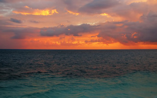 Sunset ocean clouds water boat - the foreground and a boat in the distance free wallpaper