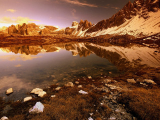 Mountain lake rocks grass sunset - the foreground and a sunset in the background free wallpaper