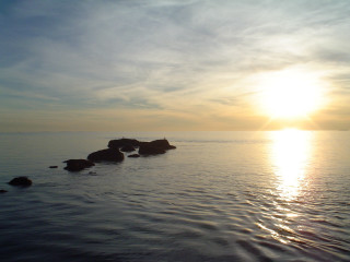 Water rocks sun distance clouds - the sun in the distance behind free wallpaper