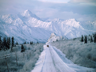 Truck driving snow covered road 3 - a mountain range in the background free wallpaper