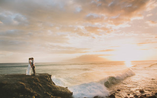 Romantic ocean sunset couple rock - the sun setting behind them free wallpaper