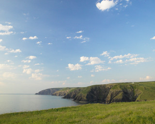 Grassy field water cliff sky - a grassy field free wallpaper