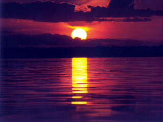 Sunset over water boat clouds 2 - a sunset over a body of water free wallpaper