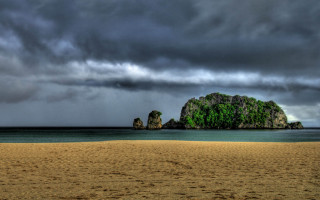 Beach rock formation cloudy sky 2 - a rock formation in the middle of it free wallpaper
