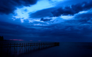 Pier cloudy dusk beach lighthouse - a lighthouse in the distance free wallpaper