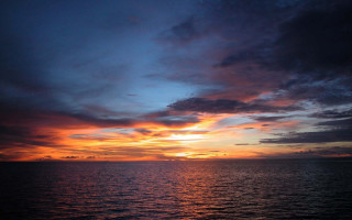 Sunset ocean clouds boat water 3 - the water below free wallpaper