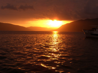 Boat sunset water mountains hills - avgust černigoj free wallpaper