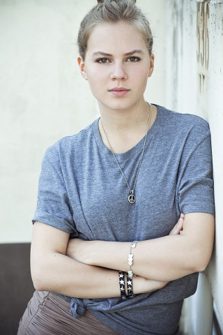 Woman arms crossed leaning wall - against free wallpaper