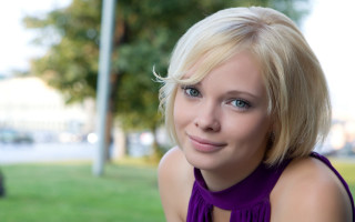 Blonde woman purple top smiling - a purple top free wallpaper