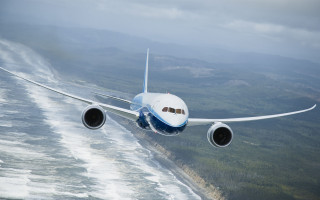 Jetliner hillside ocean cloudy sky - turnaround free wallpaper